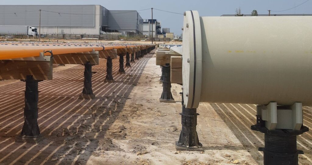 Close up of Buzon pedestals with joist kit accessory holding photobioreactor (PBR) tubes used for algae cultivation in industrial application