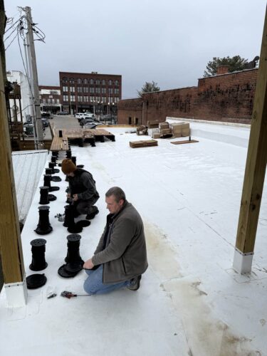 Laying the First Row of Buzon Pedestals the Length of the Rooftop Deck