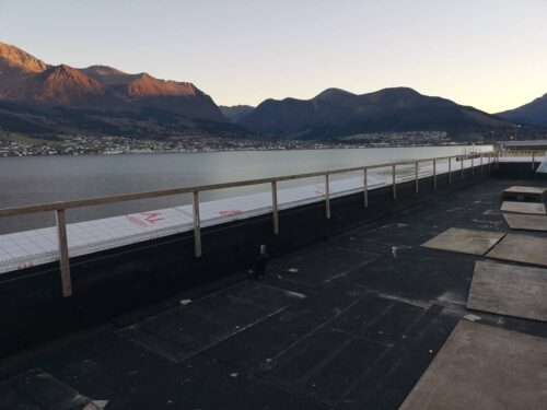 Rooftop deck view of water and mountains before pedestal pavers installation.